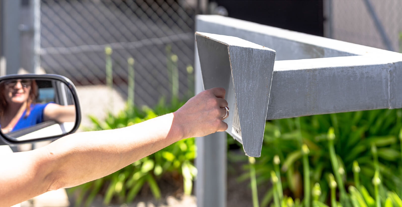 Woman reaching out of car to buzz into facility