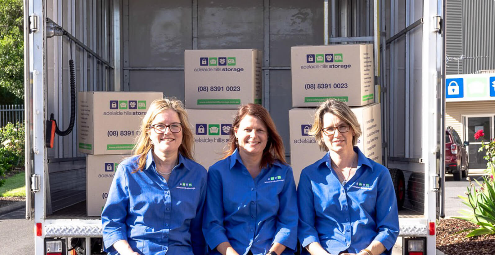 Three females outside of an open removal truck