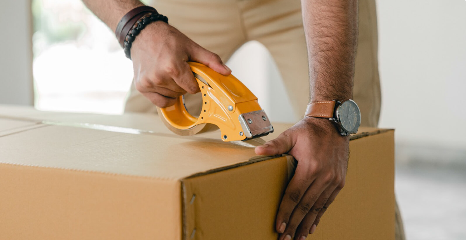 Man taping up packing box