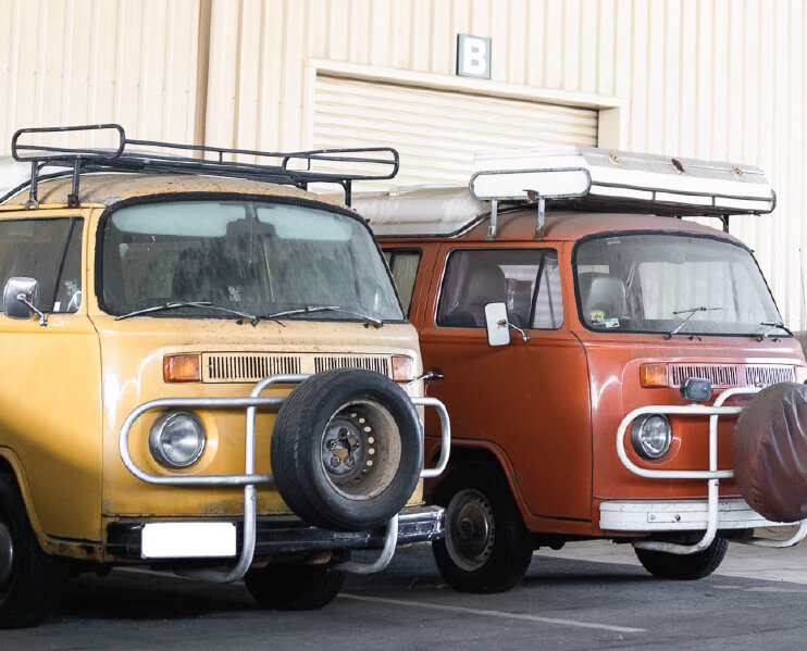 Two Volkswagen Kombi's outside