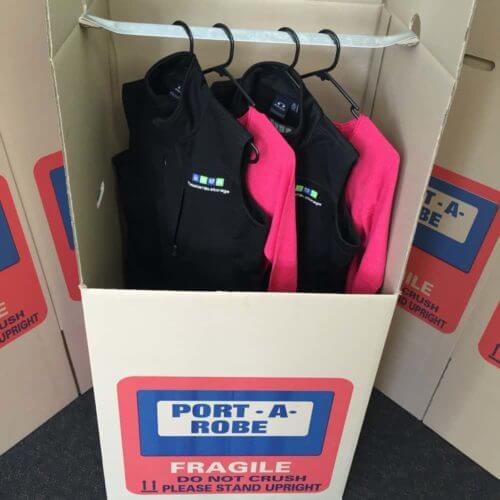 Moveable wardrobe with clothes hanging from rail